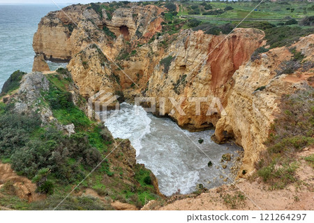 Majestic Coastal Cliffs with Lush Greenery and Turbulent Sea Majestic Coastal Cliffs with Lush Greenery and Turbulent Sea 121264297
