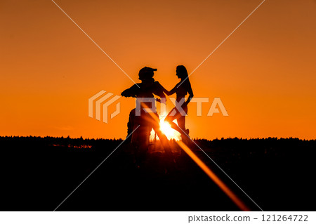 Silhouette of a girl and a man on a motorcycle.  121264722