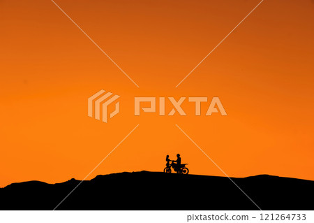 Silhouette of a girl and a man on a motorcycle. Silhouette of a girl and a man on a motorcycle. 121264733