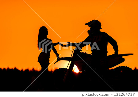 Silhouette of a girl and a man on a motorcycle. Silhouette of a girl and a man on a motorcycle. 121264737