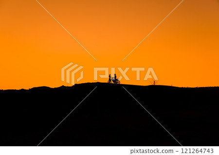 Silhouette of a girl and a man on a motorcycle. Silhouette of a girl and a man on a motorcycle. 121264743