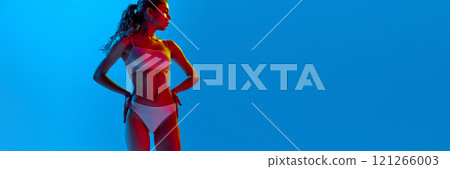 Banner, Young fit woman posing in white underwear, holding hands on hips in neon light against gradient background. 121266003