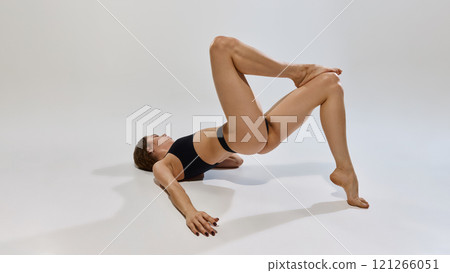 Fitness model displays flexibility with stylish athletic wear highlighting balance, control, and power while promoting body positivity and mindful movement. Fitness model displays flexibility with stylish athletic wear highlighting balance, control, and power while promoting body positivity and mindful movement. 121266051