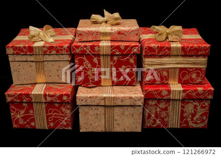 Six christmas gift boxes with gold ribbons are stacked up on a black background 121266972