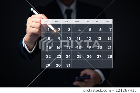Businessman highlighting date on digital calendar, indicating business planning and scheduling. Businessman highlighting date on digital calendar, indicating business planning and scheduling. 121267413