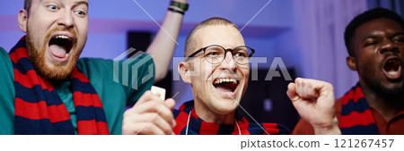 Cropped header image of portrait of excited sports fans cheering and screaming while celebrating win and wearing matching team scarves 121267457