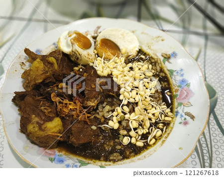 A bowl of Rawon, a rich and flavorful Indonesian beef stew. 121267618