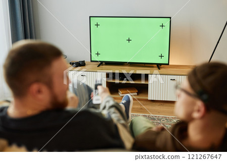 Back view of two male friends watching Tv at home together with focus on chroma key TV screen, copy space Back view of two male friends watching Tv at home together with focus on chroma key TV screen, copy space 121267647