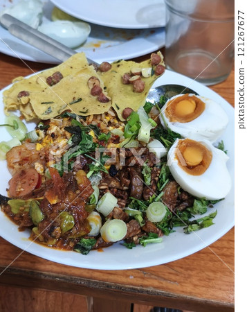 A vibrant plate of Nasi Campur, a beloved Indonesian dish 121267677