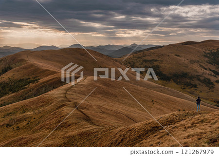 Woman Tourist Standing on Hill against Mountain Ridge 121267979