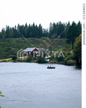 a Norwegian lake surrounded by trees on a dark rainy day a Norwegian lake surrounded by trees on a dark rainy day 121269023
