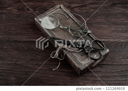 Antique accessories wooden box, old vintage retro scissors and magnifying glass. Antique accessories wooden box, old vintage retro scissors and magnifying glass. 121269910