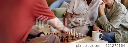 Group of senior people playing chess together in retirement home community enjoying quiet entertainment together Group of senior people playing chess together in retirement home community enjoying quiet entertainment together 121270164