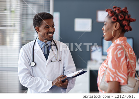 Waist up portrait of smiling African American man as doctor welcoming female patient during in office consultation Waist up portrait of smiling African American man as doctor welcoming female patient during in office consultation 121270615