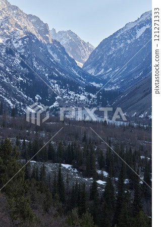 Mountain valley in early spring. Slightly snow-covered rocky Mountains slopes 121271333