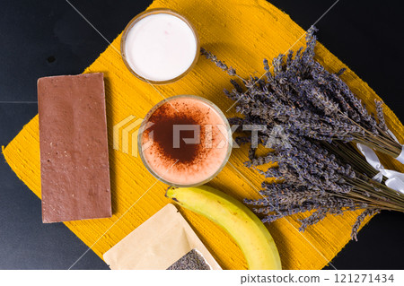 Dessert ingredients flat lay with lavender, banana, chocolate, yogurt, and a spiced drink. Dessert ingredients flat lay with lavender, banana, chocolate, yogurt, and a spiced drink. 121271434