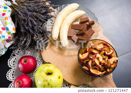 Fresh and dried fruits, chocolate, and lavender on a table. 121271447
