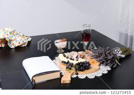 Table setting with fruit, dessert, wine, book, and lavender. Table setting with fruit, dessert, wine, book, and lavender. 121271453
