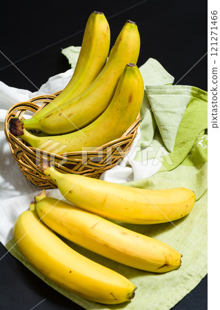 Ripe yellow bananas in a basket and on a cloth. 121271466