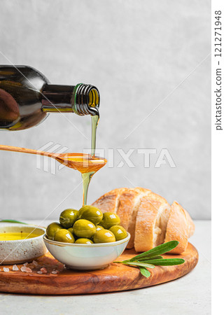 Pouring Olive Oil over Green Olives Pouring Olive Oil over Green Olives 121271948