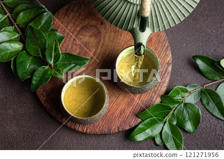 Pouring green tea into cups 121271956