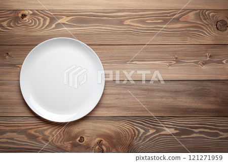 empty white plate on wooden table background empty white plate on wooden table background 121271959