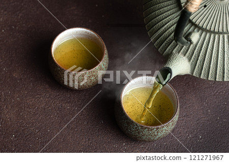 Pouring green tea into cups 121271967
