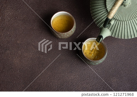 Pouring fresh tea into cups Pouring fresh tea into cups 121271968