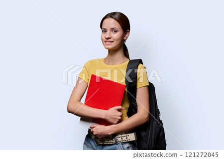 Portrait of teenager student girl holding notebook looking at camera on white background Portrait of teenager student girl holding notebook looking at camera on white background 121272045