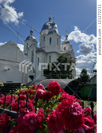 Beautiful Church with Red Roses Under a Blue Sky 121272211