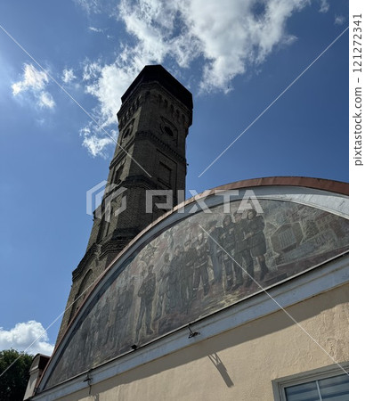 Historic Brick Tower with Mural Under Blue Sky Historic Brick Tower with Mural Under Blue Sky 121272341