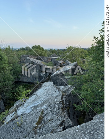 Crumbled Concrete Ruins Amid Greenery at Dusk Crumbled Concrete Ruins Amid Greenery at Dusk 121272347