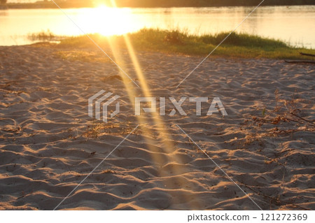 Sunset on the beach. Sand on the beach in the sunset light Evening on the beach by the lake river 121272369