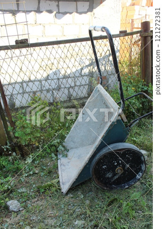 garden Wheelbarrow on the grass. Cottage equipment and use garden Wheelbarrow on the grass. Cottage equipment and use 121272381