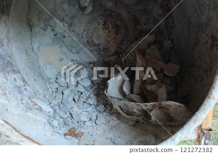 construction waste in a construction bucket mixer. The concept of the problem of the growth of construction waste. environmental pollution construction waste in a construction bucket mixer. The concept of the problem of the growth of construction waste. environmental pollution 121272382