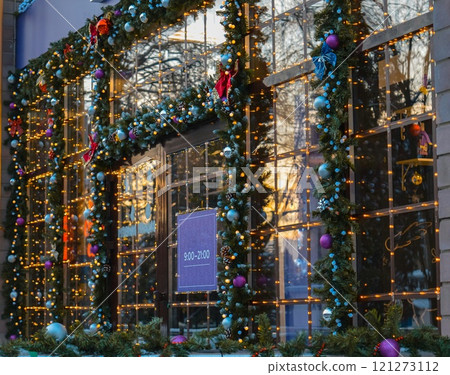 An evening look at the store Christmas decorations with pine garlands and warm lights with Christmas tree balls. . High quality photo 121273112