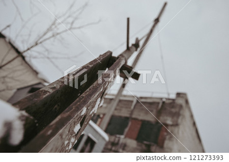 a gloomy winter shot of a metal cable supporting a rusty pipe in the heating room of factory shops in Europe. High quality photo a gloomy winter shot of a metal cable supporting a rusty pipe in the heating room of factory shops in Europe. High quality photo 121273393