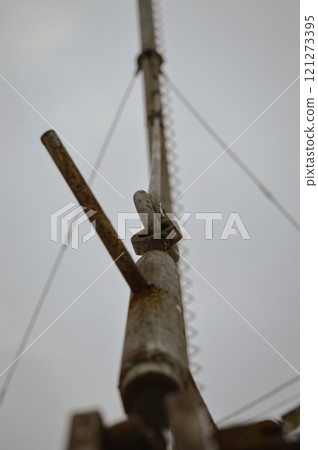 a gloomy winter shot of a metal cable supporting a rusty pipe in the heating room of factory shops in Europe. High quality photo 121273395