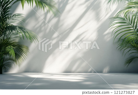 Shadows of tropical plants creating patterns on a light wall in a serene indoor space 121273827