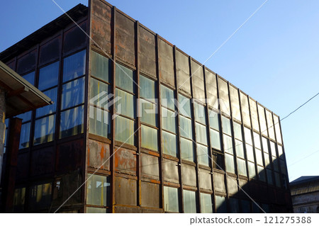 Abandoned Steel and Glass Industrial Building With Rust Under Clear Blue Sky Abandoned Steel and Glass Industrial Building With Rust Under Clear Blue Sky 121275388