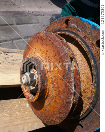 Centrifugal Pump Impeller Showing Significant Rust Deposits on Wooden Surface in an Outdoor Setting 121275391