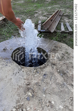 Artesian Well Fountain With Craftsman Washing Hands in a Natural Setting During Daylight Artesian Well Fountain With Craftsman Washing Hands in a Natural Setting During Daylight 121275402