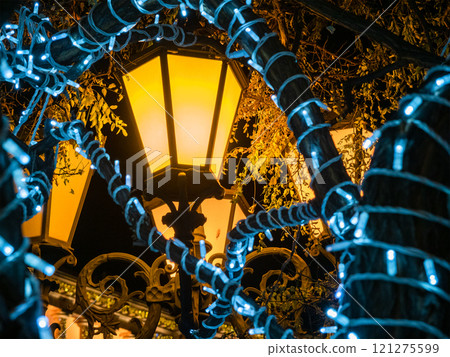 yellow urban lantern and blue garlands in night 121275599