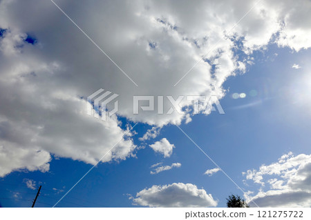 Bright Blue Sky Filled With Fluffy White Clouds on a Sunny Day Bright Blue Sky Filled With Fluffy White Clouds on a Sunny Day 121275722