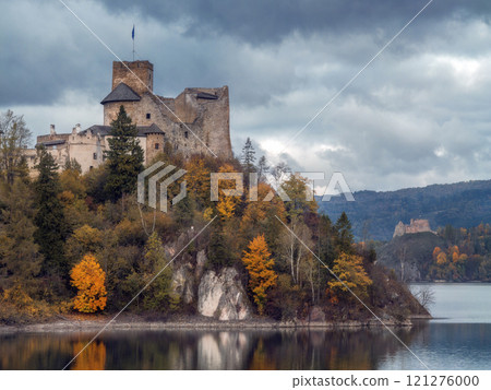 Scenic View of Niedzica Castle and Lake Czorsztyn under cloudy sky 121276000