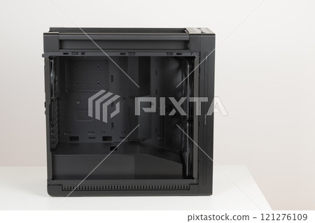 Side view of empty big tower, PC case, chassis, without upper and tempered-glass left panel. At the bottom is a cover for power supply unit. Side view of empty big tower, PC case, chassis, without upper and tempered-glass left panel. At the bottom is a cover for power supply unit. 121276109