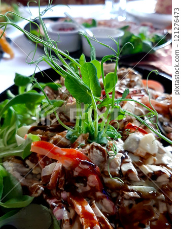 Fresh Pea Microgreens Atop Delicious Meat Salad Served at Culinary Event in Vibrant Dining Setting Fresh Pea Microgreens Atop Delicious Meat Salad Served at Culinary Event in Vibrant Dining Setting 121276473