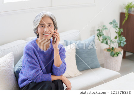 Gray-haired woman talking on smartphone Gray-haired woman talking on smartphone 121276528