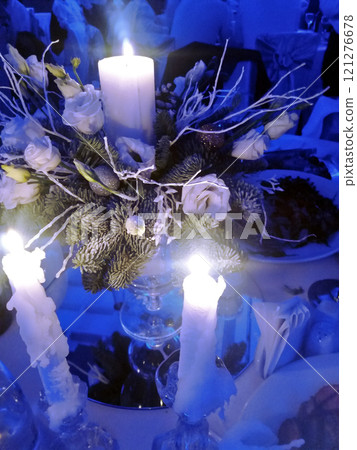 Burning Candles Green Fir Branches and Buds of White Roses. Decoration of the New Year's table and on Christmas. Blue-white cold shades Burning Candles Green Fir Branches and Buds of White Roses. Decoration of the New Year's table and on Christmas. Blue-white cold shades 121276678