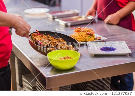 Chefs preparing traditional Chaulafan con marisco ecuadorian food in a restaurant kitchen Chefs preparing traditional Chaulafan con marisco ecuadorian food in a restaurant kitchen 121277027